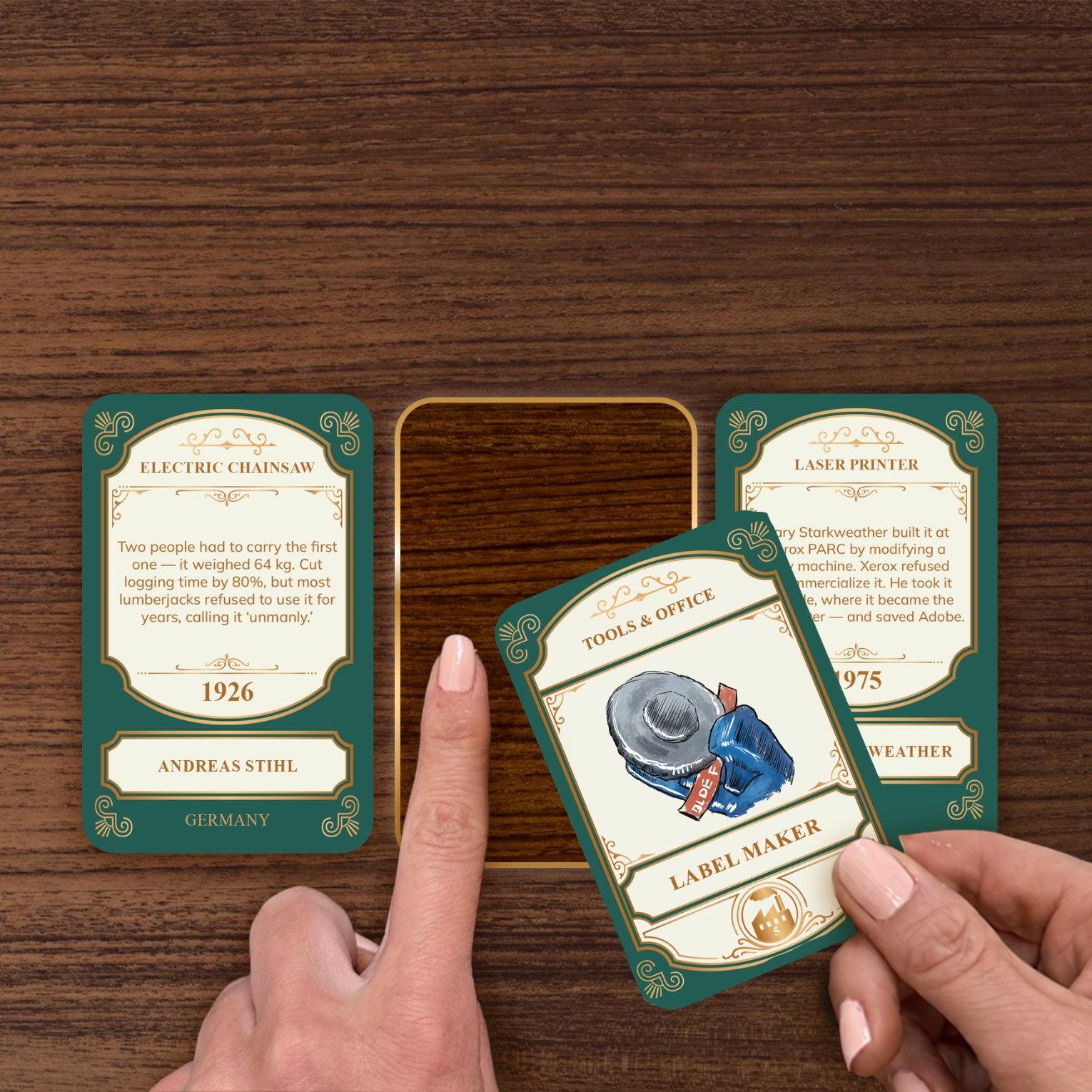 A hand lowering the Label Maker card into the gap between two cards already on the table