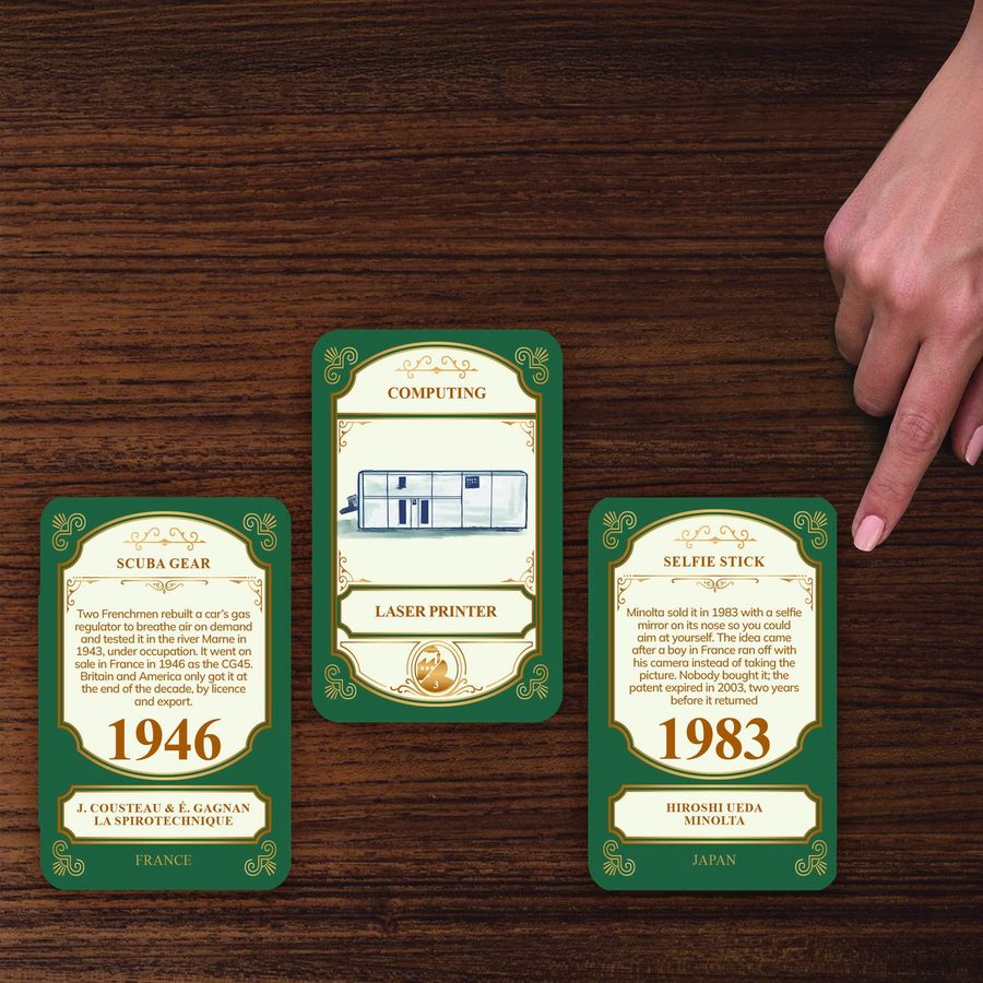Three cards in a row, the middle one still hiding its year, a second hand pointing at it